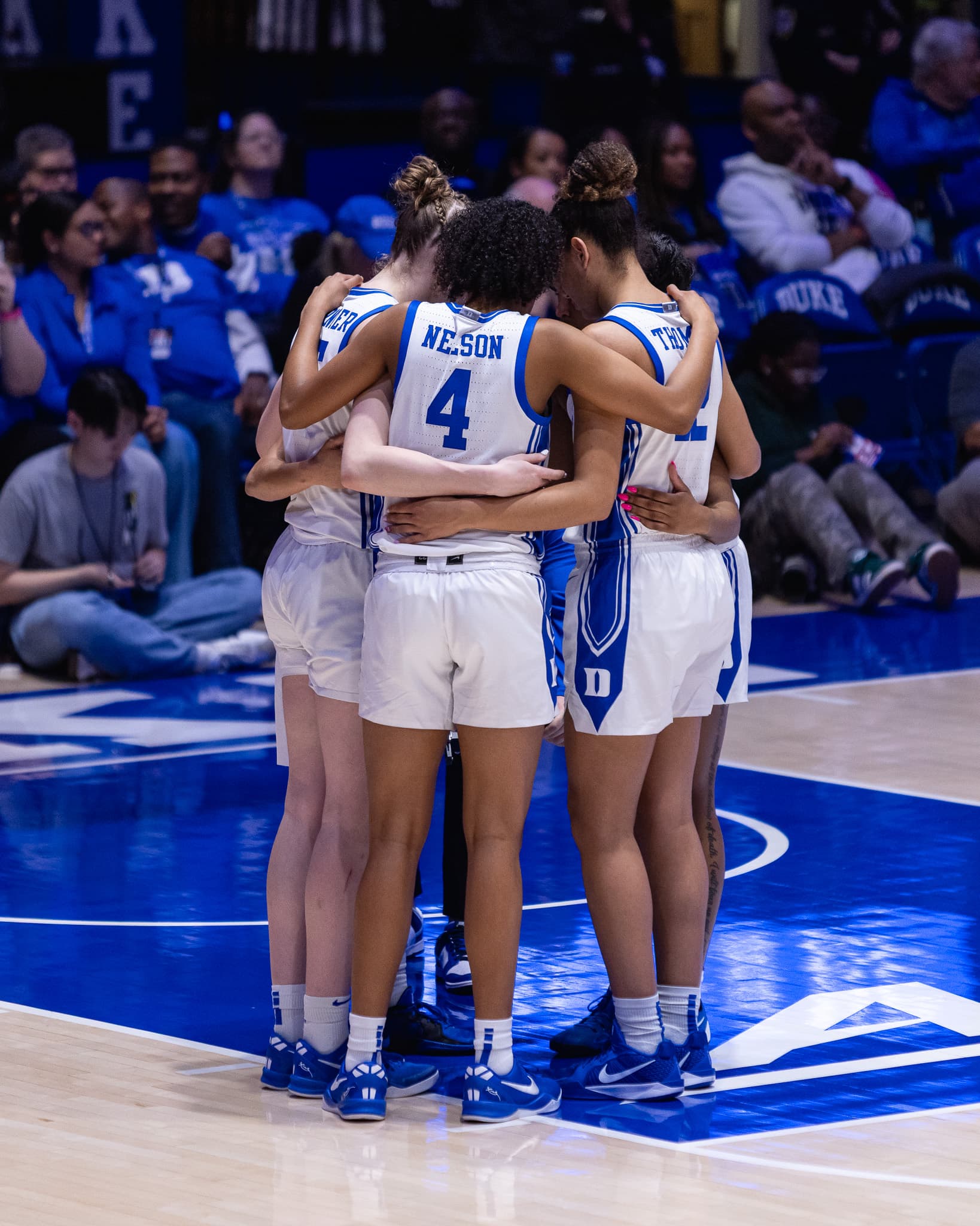 Duke players huddled together at centre court